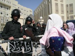 إحدى زوجات المعتقلين تحمل رضيعها في انتظار رؤية زوجها