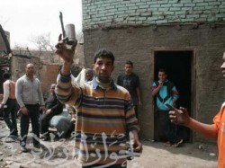 مواطن يحمل إحدى قنابل الغاز التي أطلقتها الشرطة عليهم