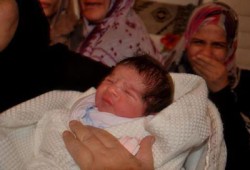 أمٌ فلسطينية تودِّع شهيدًا وتستقبل مولودًا جديدًا